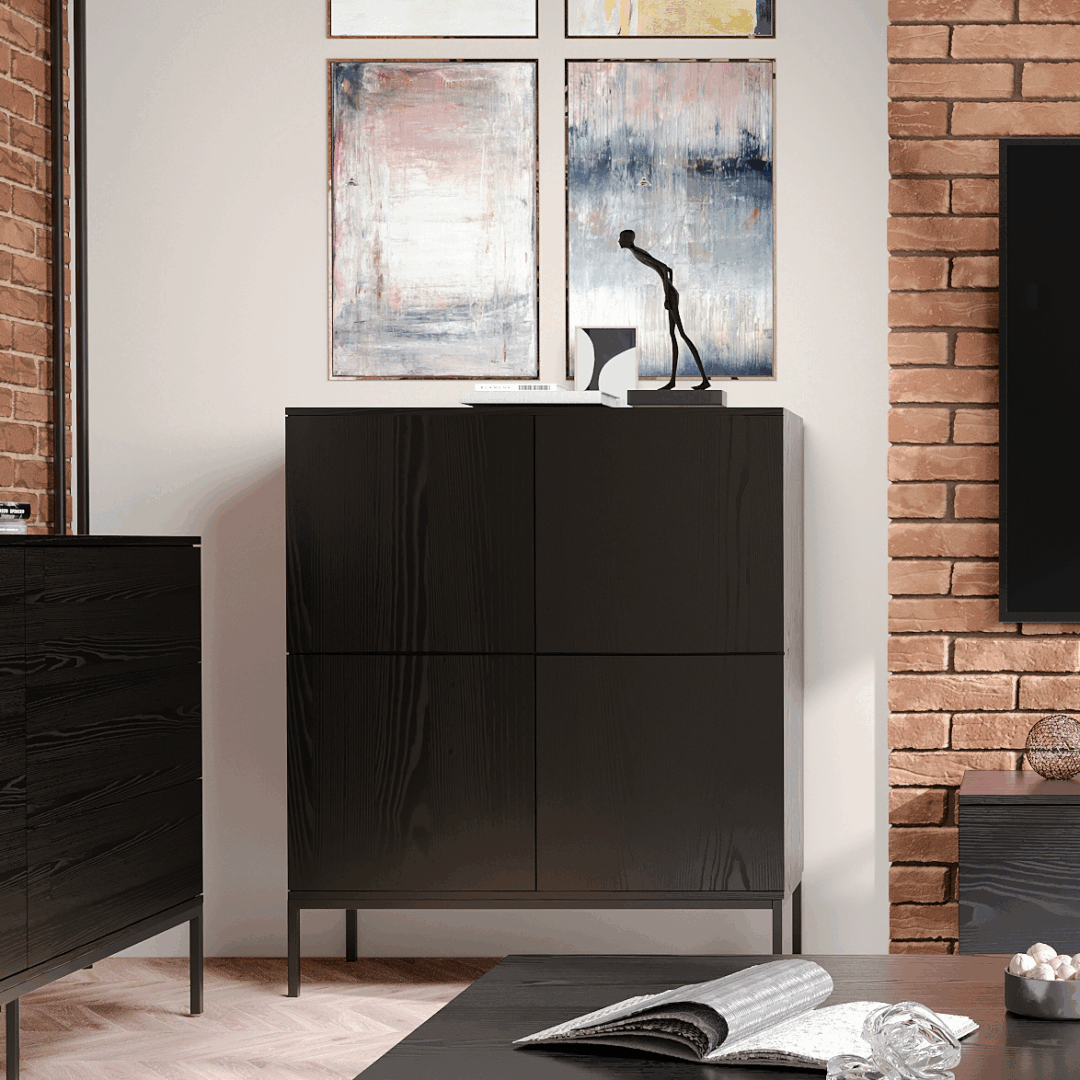 INDUST – komoda loftowa 120 cm w aranżacji salonu industrialnego Czarna komoda loftowa INDUST wysoka 120 cm z drzwiczkami i metalowymi nogami w aranżacji salonu w stylu industrialnym.